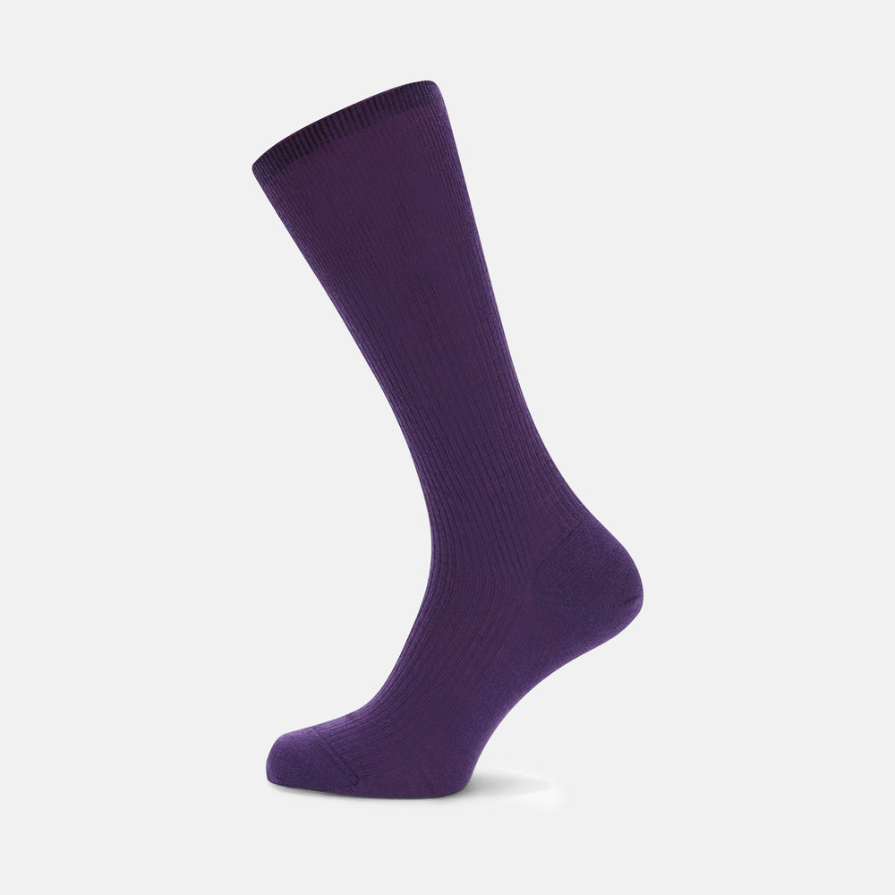 A single Turnbull & Asser Dark Purple Mid-Length Merino Wool Sock stands upright on a plain light gray background, showcasing its ribbed texture and reinforced toe and heel for premium quality.