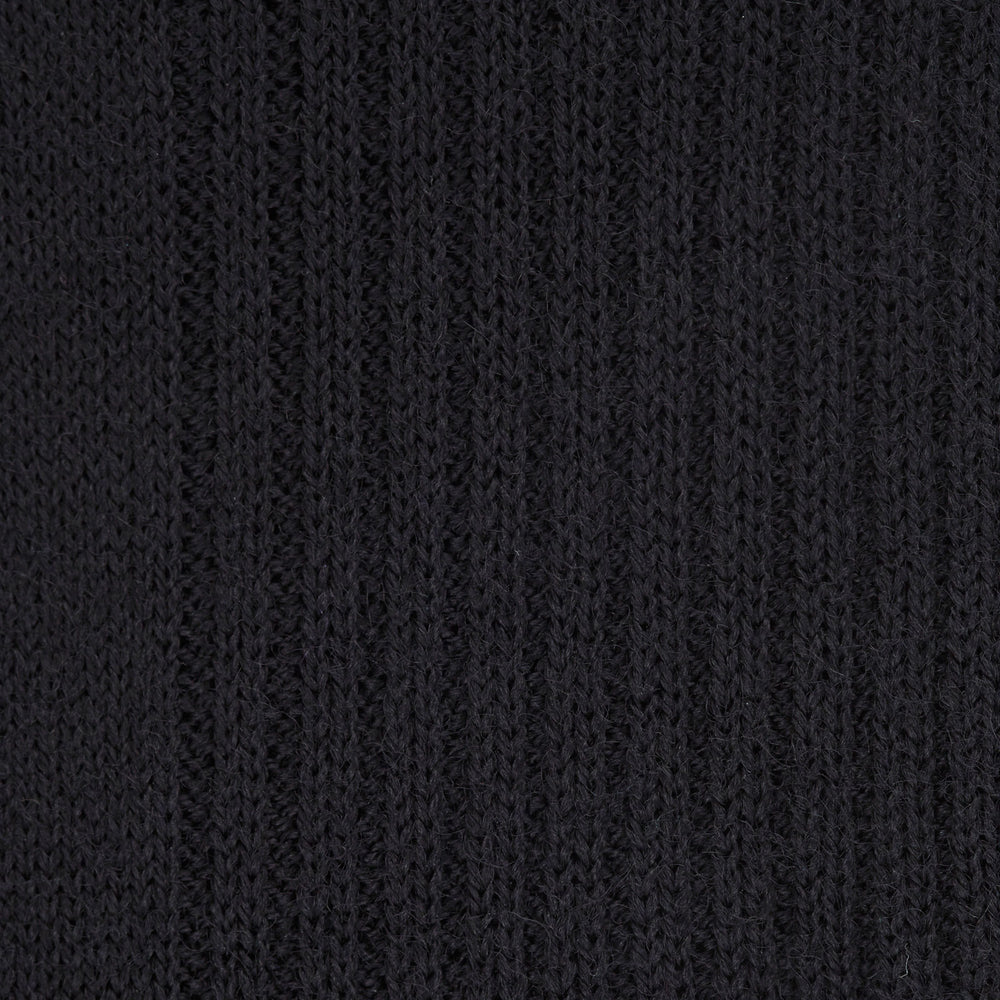 A single Turnbull & Asser Black Long Merino Wool Sock stands upright on a white background, highlighting its ribbed texture that runs from toe to just below the knee.