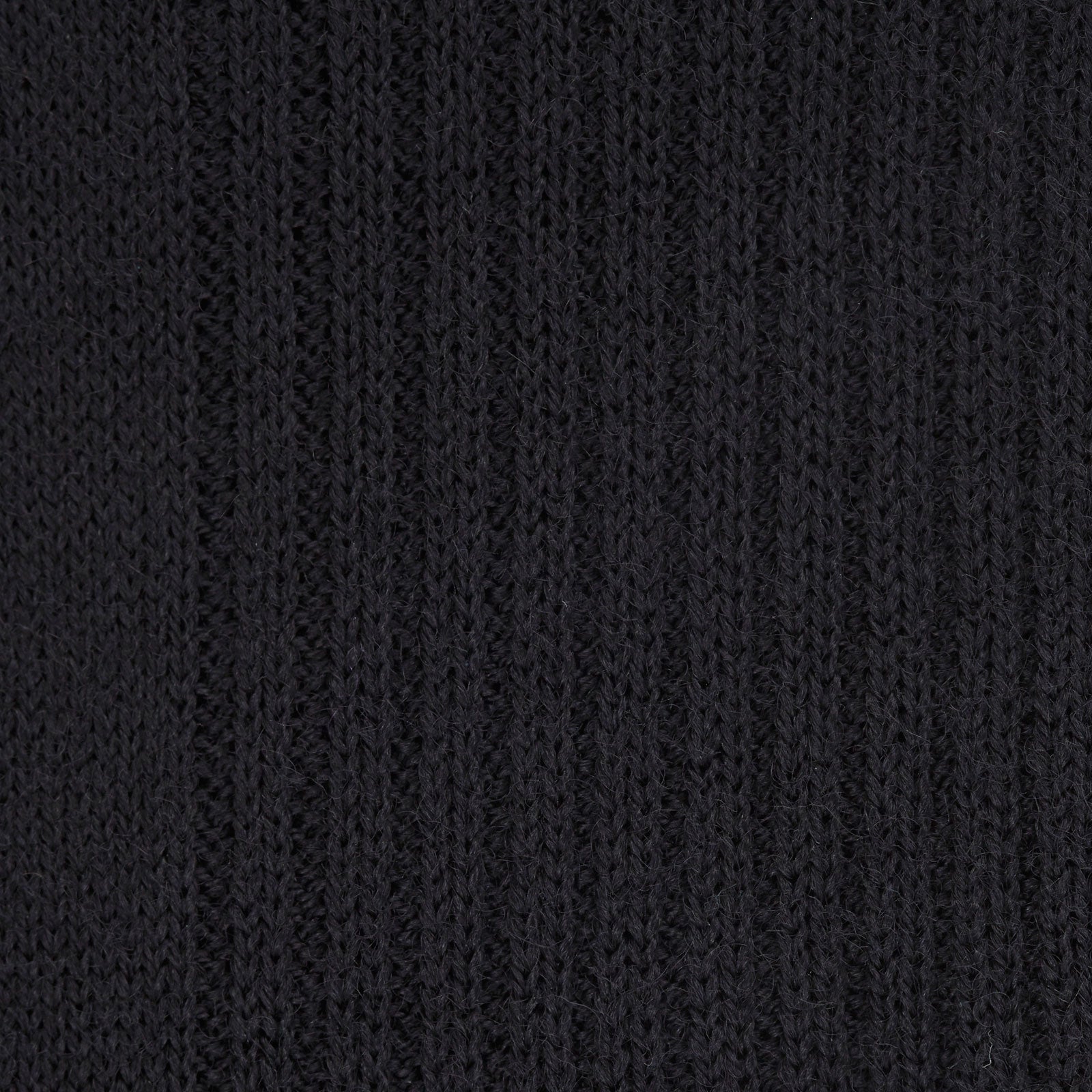 View 2 of product A single Turnbull & Asser Black Long Merino Wool Sock stands upright on a white background, highlighting its ribbed texture that runs from toe to just below the knee.