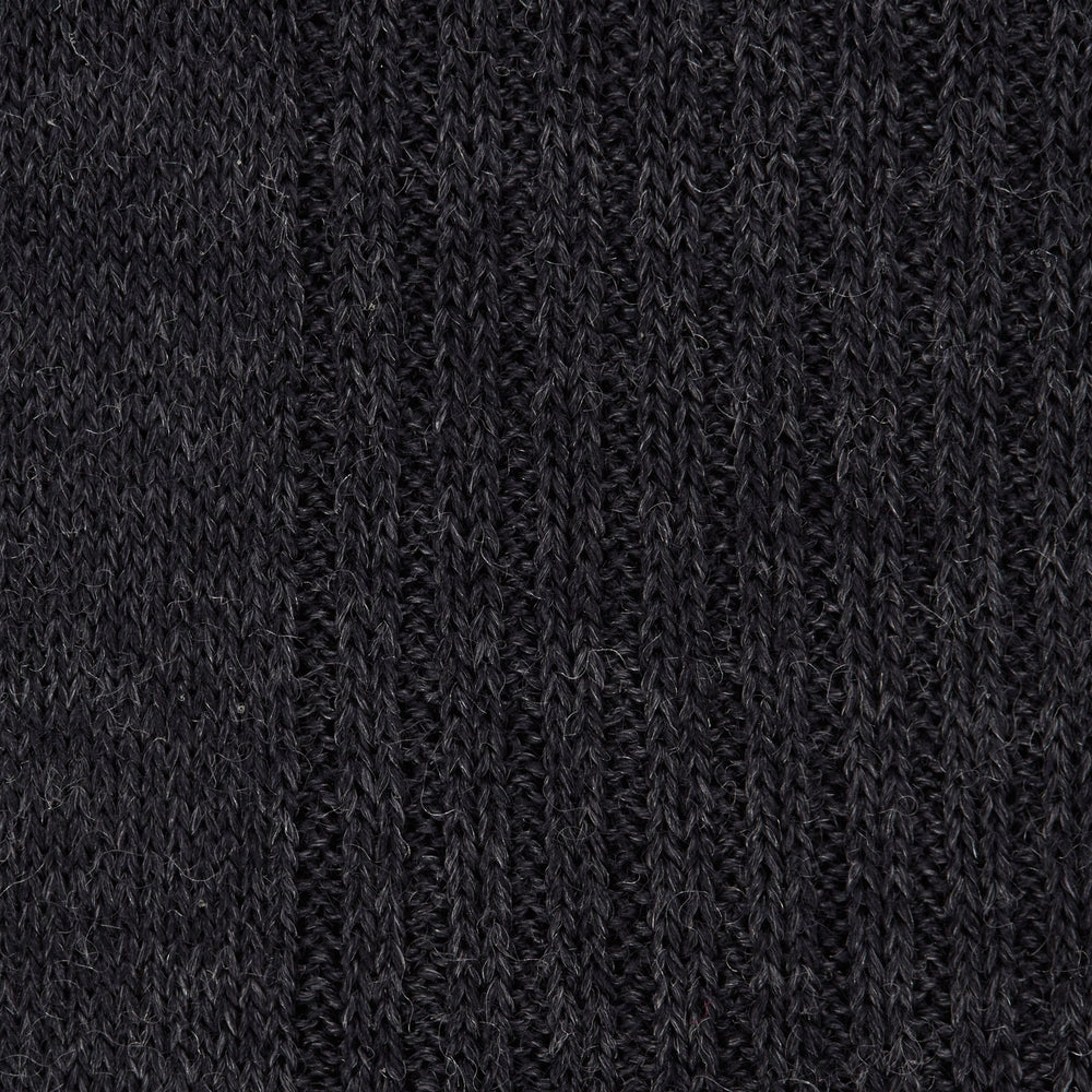 A single Charcoal Long Merino Wool Sock by Turnbull & Asser is shown upright on a white background. Featuring a ribbed texture and snug fit, these luxury men's socks blend style with comfort.