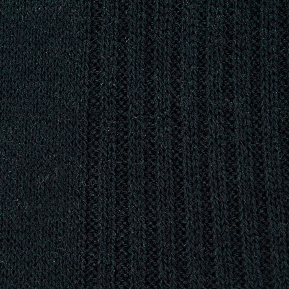 A single Racing Green Long Merino Wool Sock by Turnbull & Asser is shown on a light gray background, positioned as if worn to highlight its ribbed texture and comfortable fit.