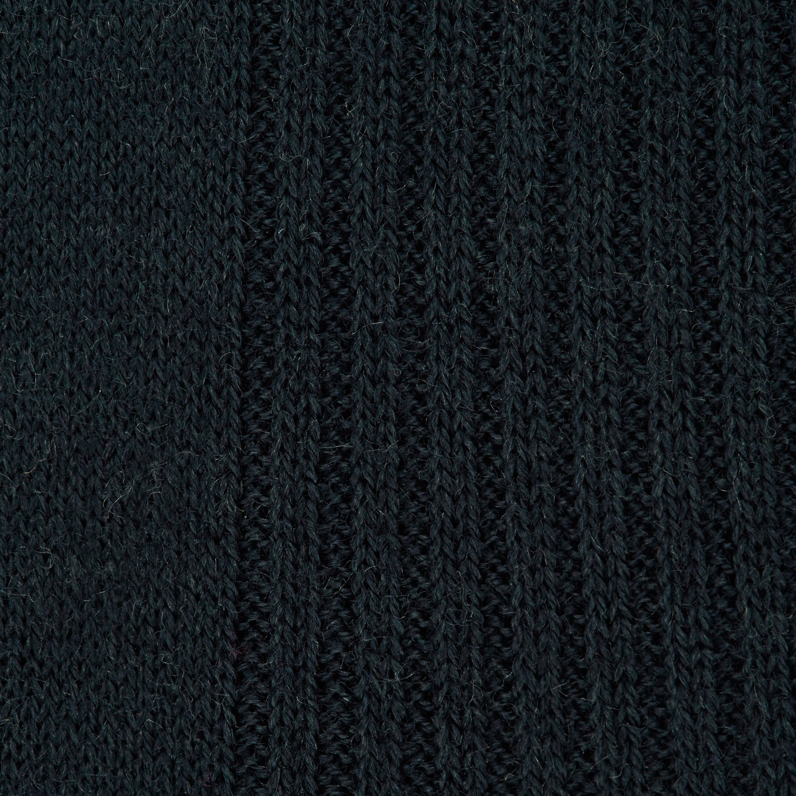 View 2 of product A single Racing Green Long Merino Wool Sock by Turnbull & Asser is shown on a light gray background, positioned as if worn to highlight its ribbed texture and comfortable fit.