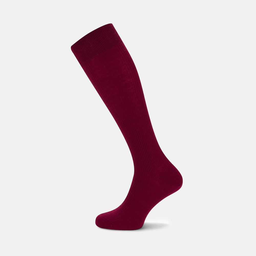 A single Bordeaux Long Merino Wool Sock by Turnbull & Asser stands upright on a light gray background, showcasing the brand’s luxurious men’s sock style.