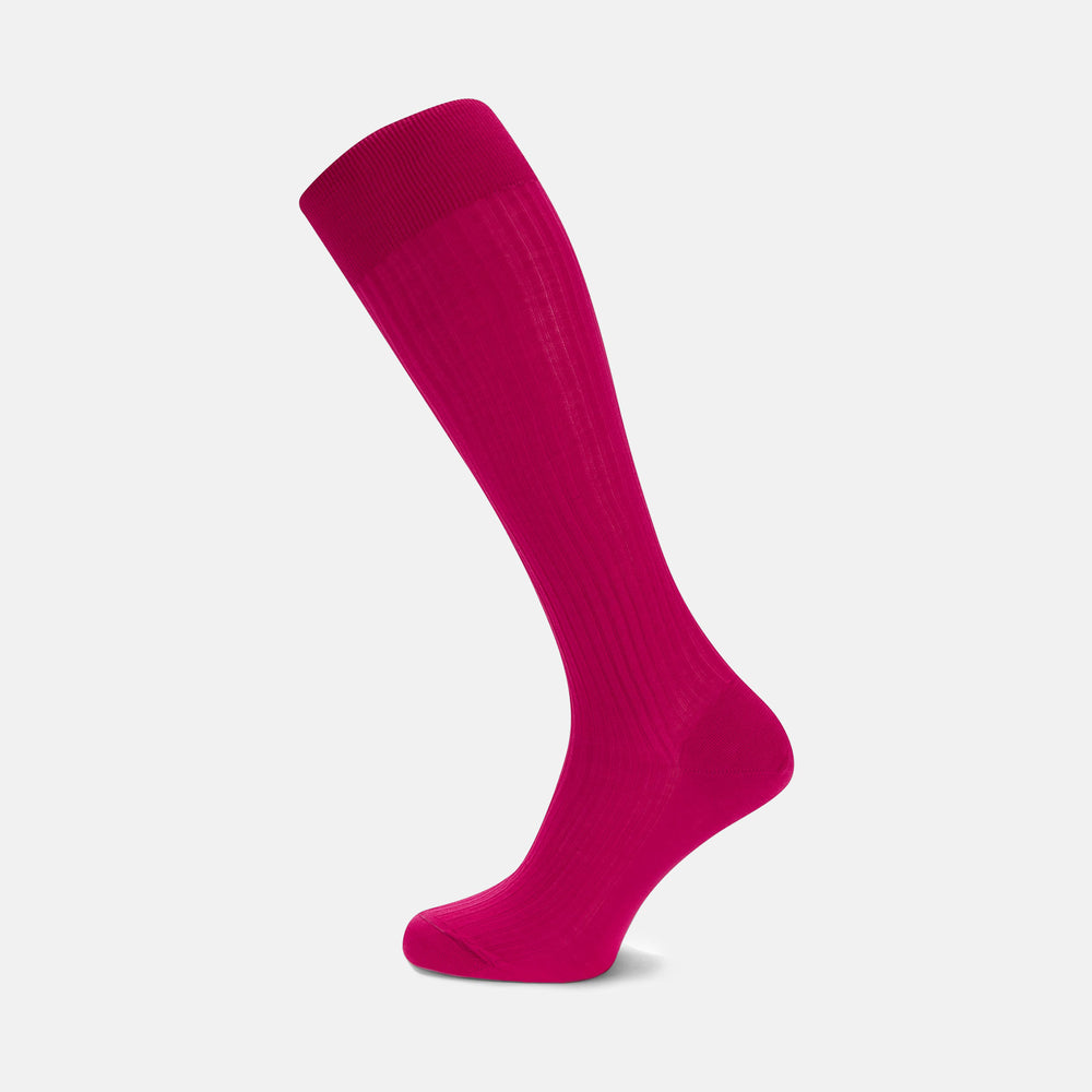 A single Hot Pink Long Cotton Sock by Turnbull & Asser, crafted from premium Egyptian cotton with a ribbed texture. Displayed on a light gray background, it's angled to show the side and slightly elevated toe.