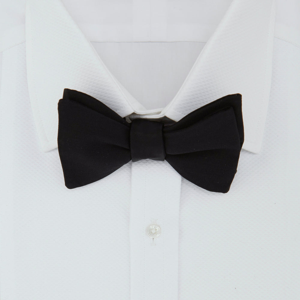 The Turnbull & Asser Black Barathea Bow Tie, made from luxurious silk with a classic, symmetrical shape, is displayed against a plain white background—ideal for formal occasions.