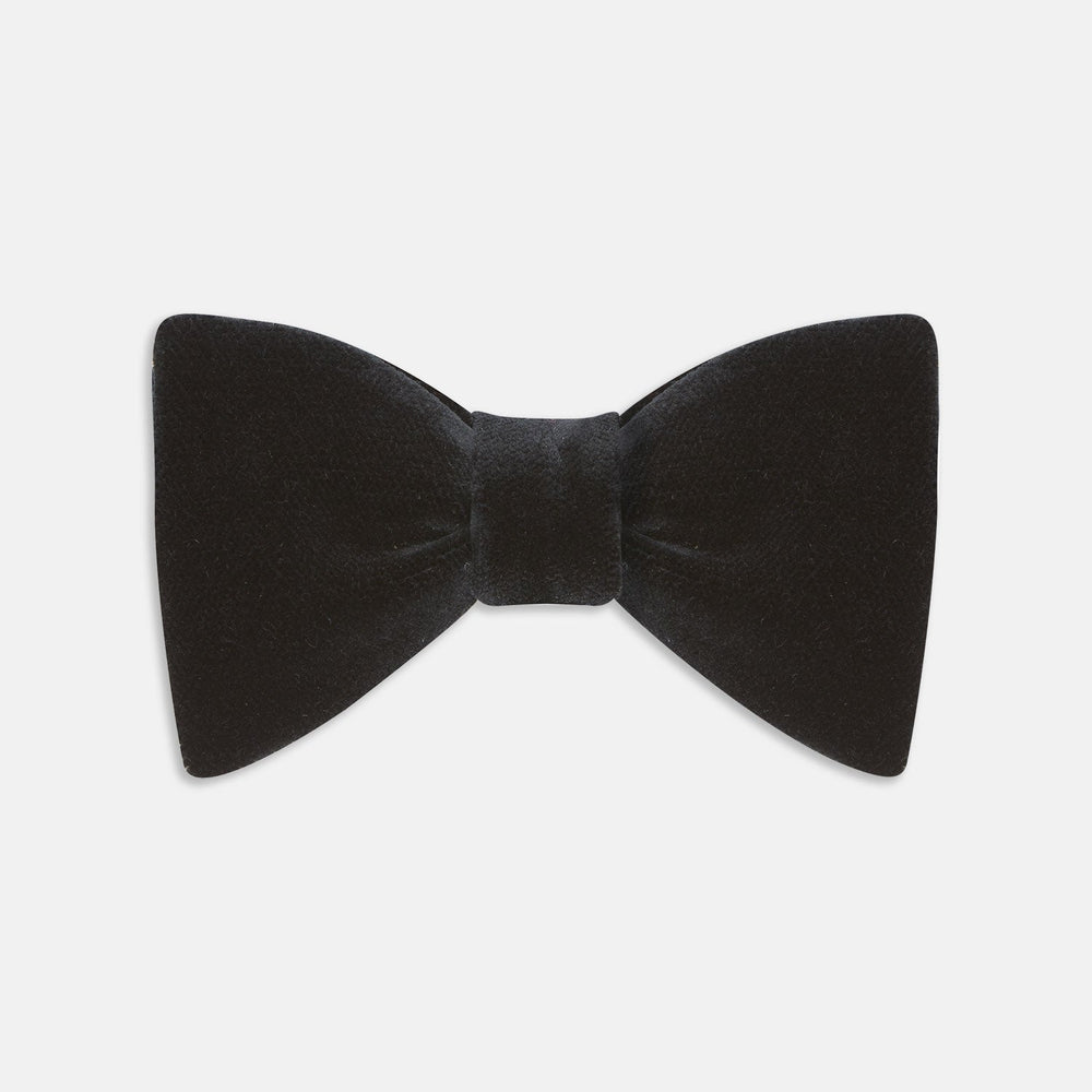 The Turnbull & Asser Black Velvet Bow Tie, shown against a plain white background, is an elegant choice for formal occasions.