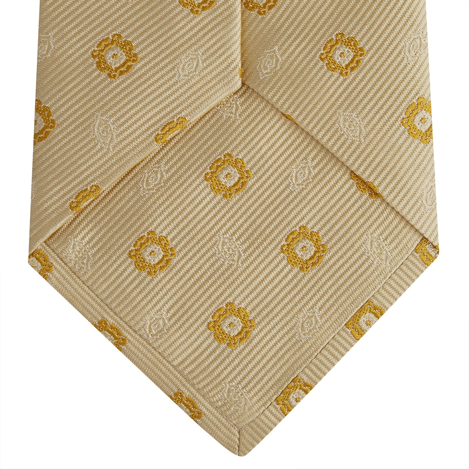 View 4 of product The Turnbull & Asser Soft Yellow Floral Jacquard Stripe Silk Tie features a rolled-up beige design with subtle texture and small yellow floral patterns evenly spaced throughout.
