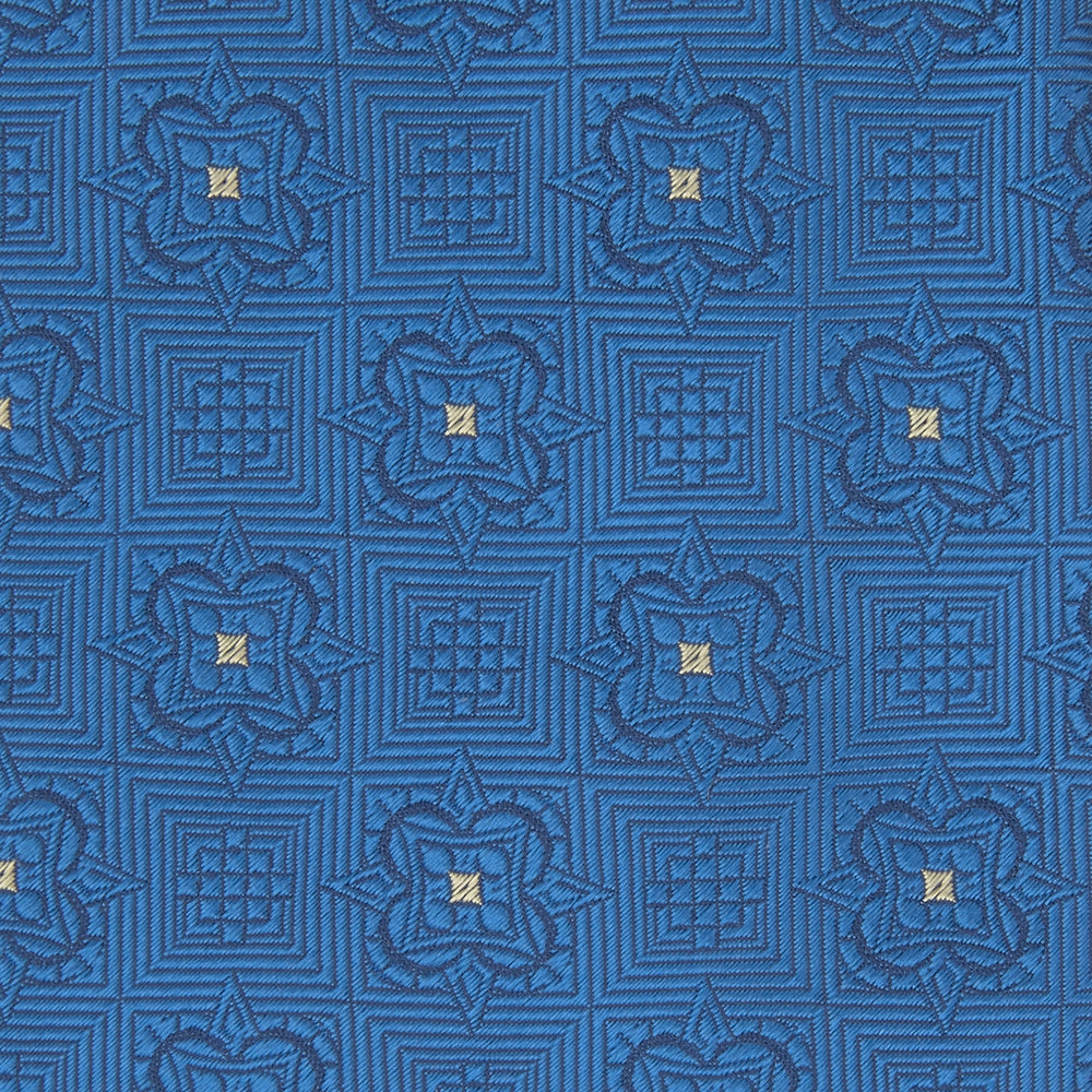 The Turnbull & Asser Blue Flower Mosaic Silk Tie features a blue silk fabric with a detailed geometric and floral design, accented in lighter blue and white, displayed on a white background.