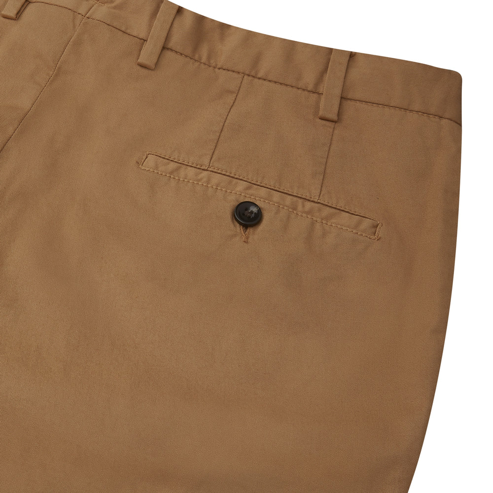 The Tan Garment Dyed Cotton Chinos from Turnbull & Asser, crafted from Italian cotton twill with belt loops, front pockets, and a button closure, are shown laid flat on a white background.