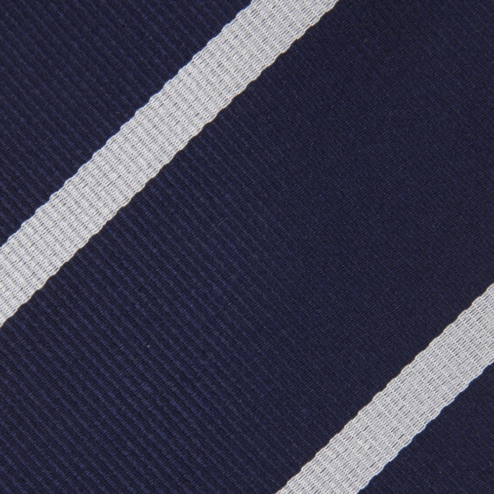 The Turnbull & Asser Seven-Fold Navy and White Blazer Stripe Repp Silk Tie, elegantly rolled at one end, is displayed on a plain white background.