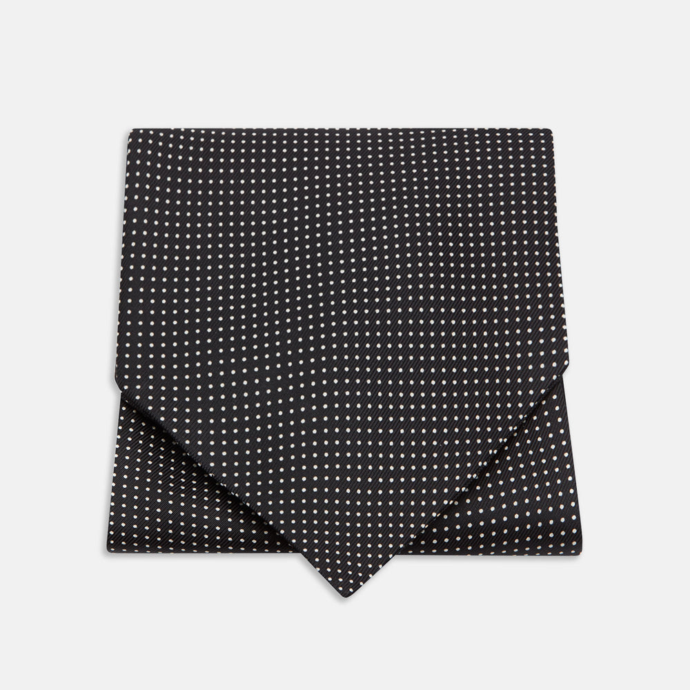 The Turnbull & Asser Black and White Mini Spot Silk Cravat, featuring a refined polka dot pattern, is displayed elegantly on a plain light background—an ideal wedding guest accessory.