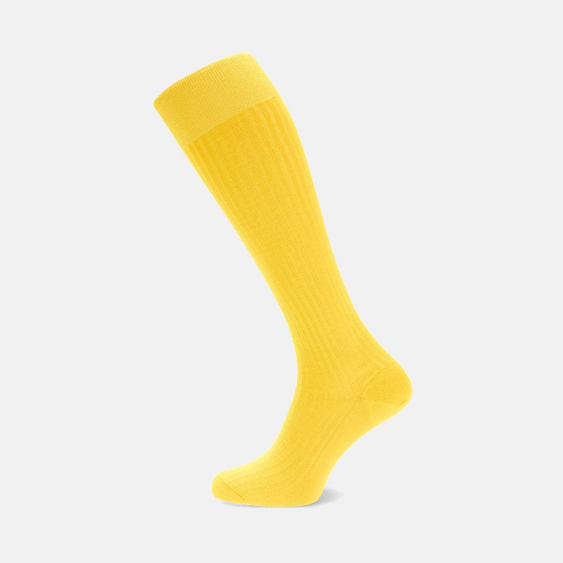 A single Bright Yellow Long Cotton Sock by Turnbull & Asser is shown on a light gray background, featuring a ribbed leg and smooth foot, crafted from luxurious Fil d'Ecosse cotton.